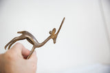 Vintage bronze gazelle held in hand, detailing its slender form and light patina.