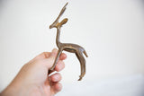 Small vintage African bronze gazelle held in hand, showing its scale and aged patina.