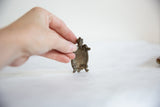The small vintage African bronze turtle held to show its handmade form and scale.