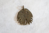 Incised patterns and rustic texture of a vintage handmade African bronze jellyfish pendant.