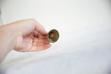 The aged interior and handmade clapper of a vintage African bronze bell.
