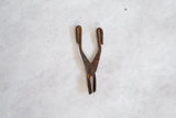 Small vintage African tool with a scissor-like body and dark, weathered bronze surface.