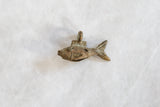 Aged bronze patina and handmade texture on a tiny African fish pendant.