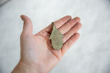 Back view of the vintage African bronze hut pendant showing its flat, handmade shape.