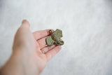 Vintage oxidized bronze elephant pendant held in hand to show its small size.