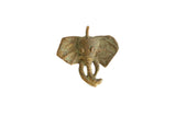 A collectible African elephant head pendant featuring a rich, oxidized golden patina.