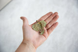 Handheld vintage African elephant pendant with rich oxidized golden patina.