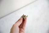 Vintage African bronze elephant pendant held to demonstrate its scale and mesh construction.