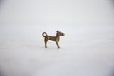 A side profile of the vintage African bronze ram, highlighting its handmade form and curled tail.