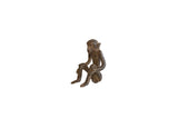 Vintage African dark bronze sitting monkey sculpture with charming handmade texture.