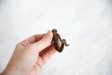 Dark bronze sitting monkey from the back, highlighting handmade texture.