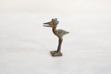Aged patina and handmade texture on a vintage African bronze stork collectible.