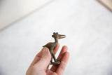 Profile view of a vintage African bronze stork with a decorative crown and open beak.