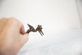 Vintage African bronze stork held in hand to show its small scale and handmade details.