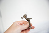 Vintage African bronze stork collectible held in hand to illustrate its petite scale.