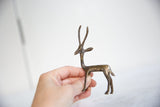 Side profile of a vintage African dark bronze gazelle held in a hand.