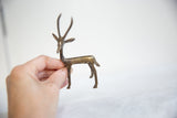 Vintage bronze gazelle held in hand to demonstrate its small scale and handmade texture.