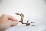 Hand holding vintage African dark bronze gazelle, showing its unique handmade texture.