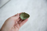 The concave interior of the African bronze mask pendant showing a deep green oxidized patina.