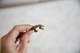 Vintage African pangolin pendant held in hand to show its small scale and texture.