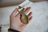 Aged bronze back of African mask bottle opener, showing handcrafted texture.