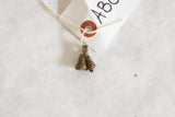 Aged patina and handcrafted texture on a vintage African bronze double bell pendant.