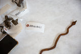 Vintage African iron snake's slithering, textured, rustic brown body showing patina.