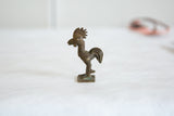 Side view of the vintage African bronze rooster highlighting its etched texture and form.