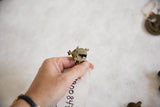 Side view of a vintage African bronze turtle pendant revealing its handmade details.