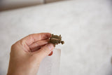 Vintage African bronze turtle pendant held to show its small, collectible scale and handmade charm.