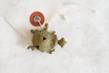 Aged bronze turtle pendant with tri-circle wire design, shown with its vintage tag.
