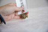 Vintage bronze turtle pendant held in hand to demonstrate its small, collectible size.