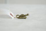 Side profile of the African bronze turtle pendant with its criss-cross mesh shell.