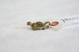 Side profile of the vintage African bronze turtle pendant's oxidized mesh shell.
