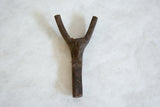 Dark brown, textured surface of the handmade African wooden talisman.