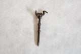 Handmade African bronze pin featuring a stylized bird and rustic patina.