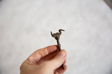Vintage African bronze bird pin held in hand to show its scale.