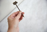 Full view of the vintage double chameleon bronze pin held for scale.