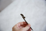 Textured bronze surface and sculpted form of a vintage African chameleon pin.