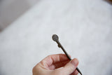 Handmade coiled spiral detail on the head of the vintage African bronze pin.