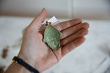 Concave back of the African pendant showing the textured green oxidized finish.