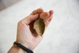 Inside view of the concave vintage bronze mask pendant showing its handmade, rustic patina.