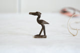Vintage African dark bronze stork, side profile with aged patina.