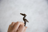 Handmade dark bronze African stork with fish, showcasing its etched details and aged patina.