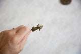 Vintage bronze hare pendant held to show its scale and oxidized texture.