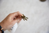 The sculpted legs and underside of the handmade bronze hare pendant.
