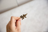 Vintage African bronze crocodile pendant held in hand, highlighting its detailed form and scale.