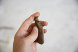 Vintage bronze rhino figure held in hand, illustrating its small, collectible size.