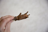 Hand holding vintage African copper alloy rhino, showing its rugged texture and patina.