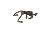 Vintage African bronze man sculpture in a stylized crawling pose with a dark, aged patina.